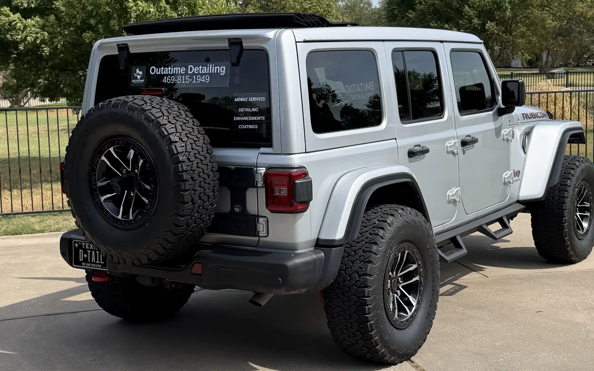The OutaTime Detailing Jeep, rear three-quarter view, parked on a driveway